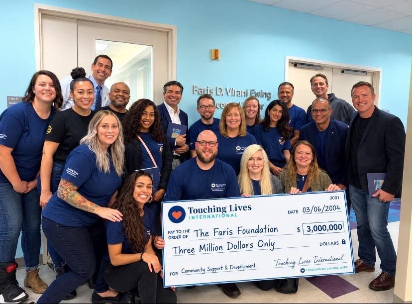 Group holding a presentation cheque indoors