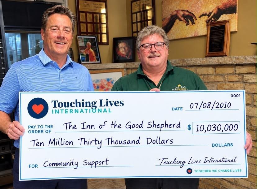 Two people standing beside a presentation cheque