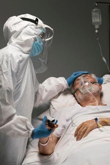 Medical worker leaning over a patient in a hospital bed